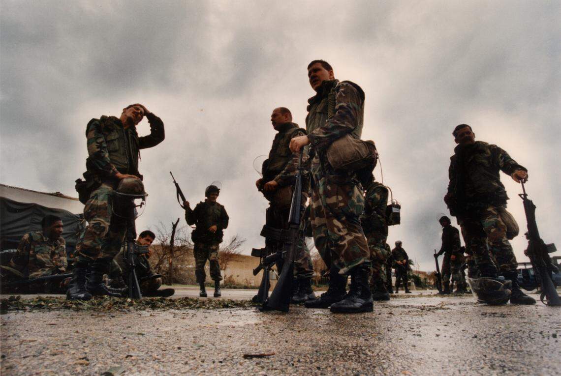 In this file photo from Aug. 24, 1992, a group of Florida National Guardsmen from Homestead take a break while guarding the Cutler Ridge Mall hours after Hurricane Andrew blasted many of the stores’ buildings. The Guardsmen had just stopped looters at the mall’s damaged Payless Shoe Store. This company was in a Miami armory when the storm hit that morning, then immediately went into action. It was hours before they were allowed to call home to find out how their families fared.