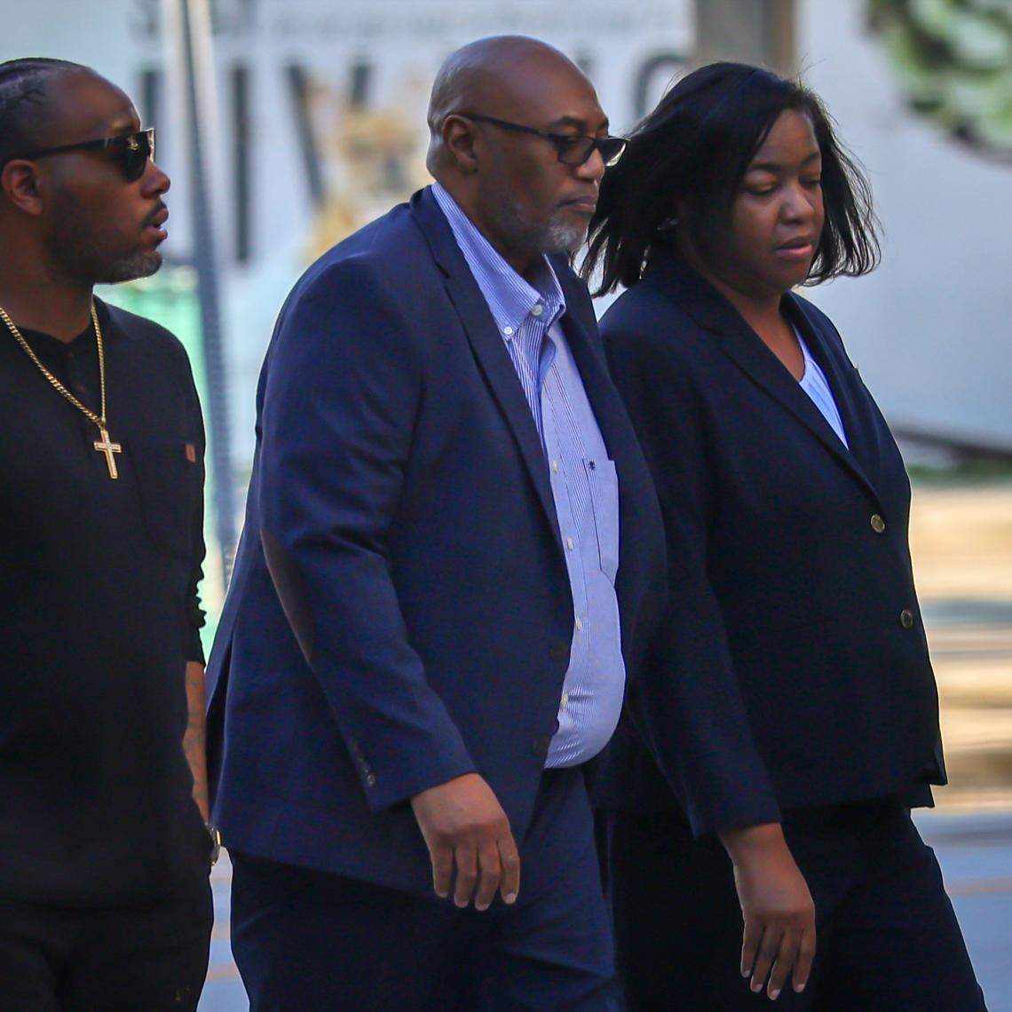 An unidentified man, left, escorts Arthur Gatlin and his wife Charmaine Gatlin, right, the former chief operating officer of the Jackson Health Foundation, for her sentencing at the Wilkie D. Ferguson Jr. Courthouse on Wednesday, Dec. 10, 2025, in Miami, Florida.