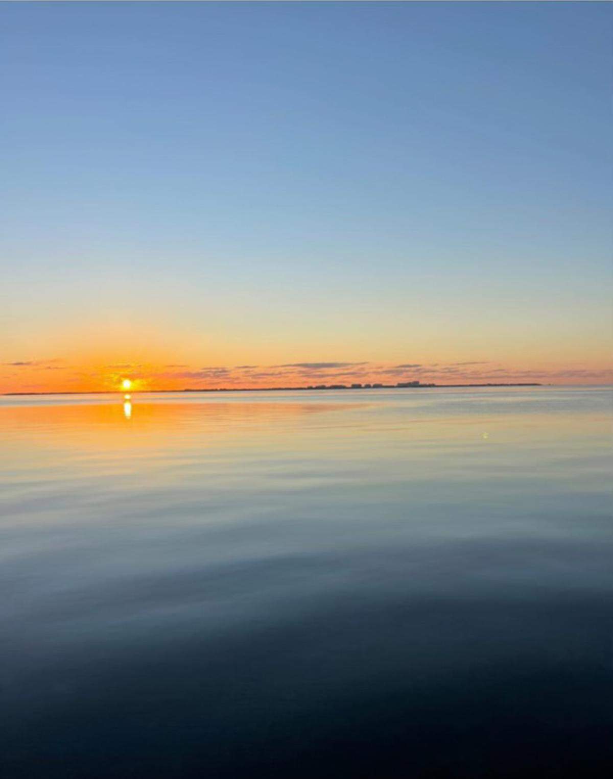 A view of the sunrise from the balcony of Grove Isle condo owner Wendy Gordon before construction of the seven-story Vita condo building began.