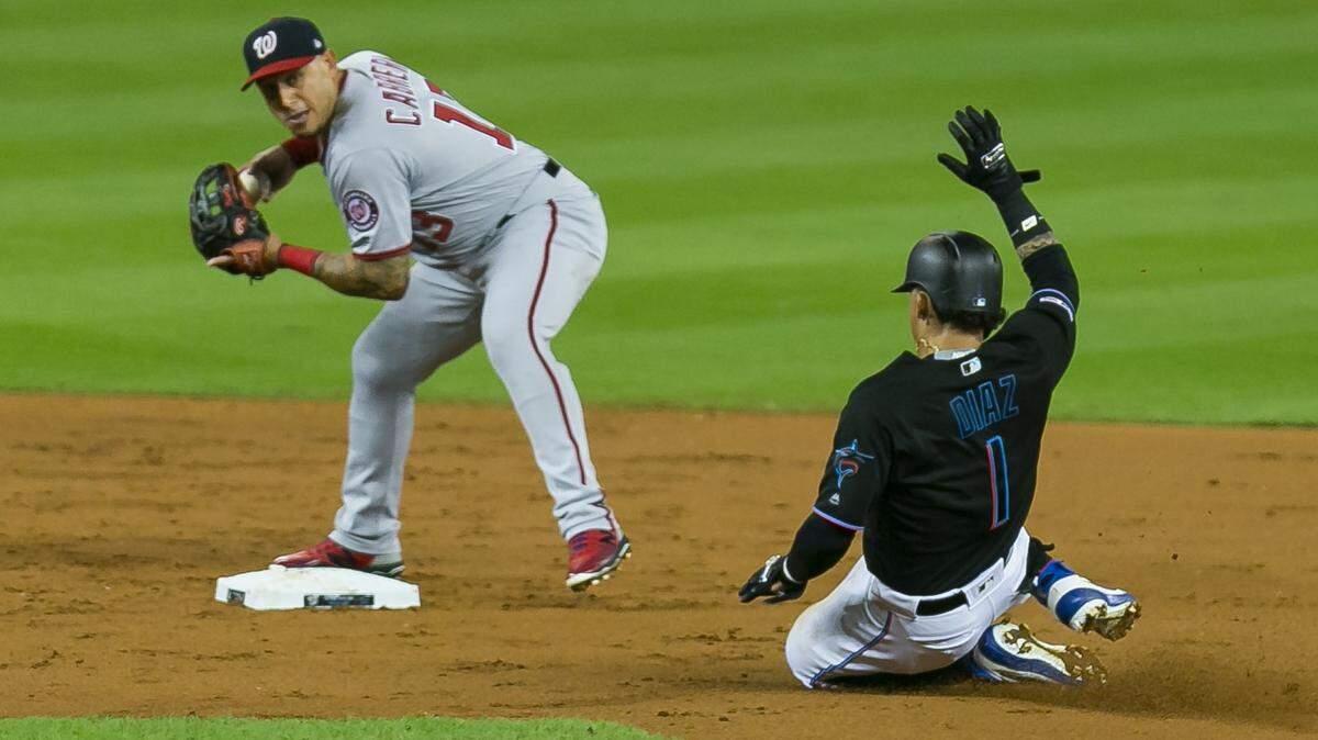 Washington Nationals third baseman Asdrubal Cabrera (13) throws to first base while tagging out Miami Marlins second baseman Isan Diaz (1) in the second inning of a baseball game at Marlins Park in Little Havana on Friday, September 20, 2019.
