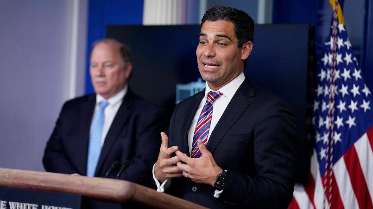 Detroit Mayor Mike Duggan, left, listens as Miami Mayor Francis Suarez speaks during a press briefing at the White House on Friday, Feb. 12, 2021, in Washington.