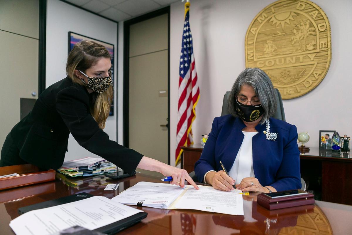 Legislative Affairs Director Nicole Tallman, left, reviews documents with Miami-Dade County Mayor Daniella Levine Cava at her office inside the Stephen P. Clark Government Center in downtown Miami on Wednesday, Feb. 24, 2021.