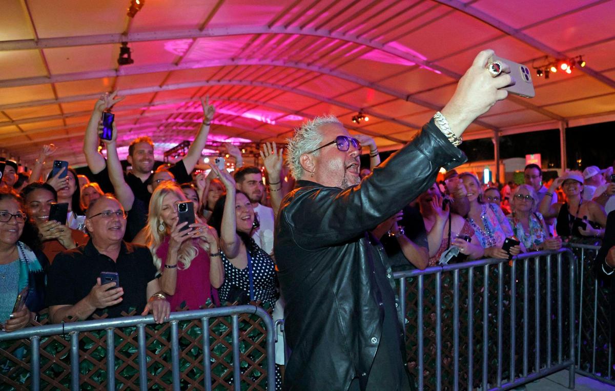 Guy Fieri, chef and Food Network celebrity, takes a selfie with fans at the South Beach Wine & Food Festival on the sand by the Ritz Carlton in Miami Beach, Florida on Saturday, February 25, 2023.