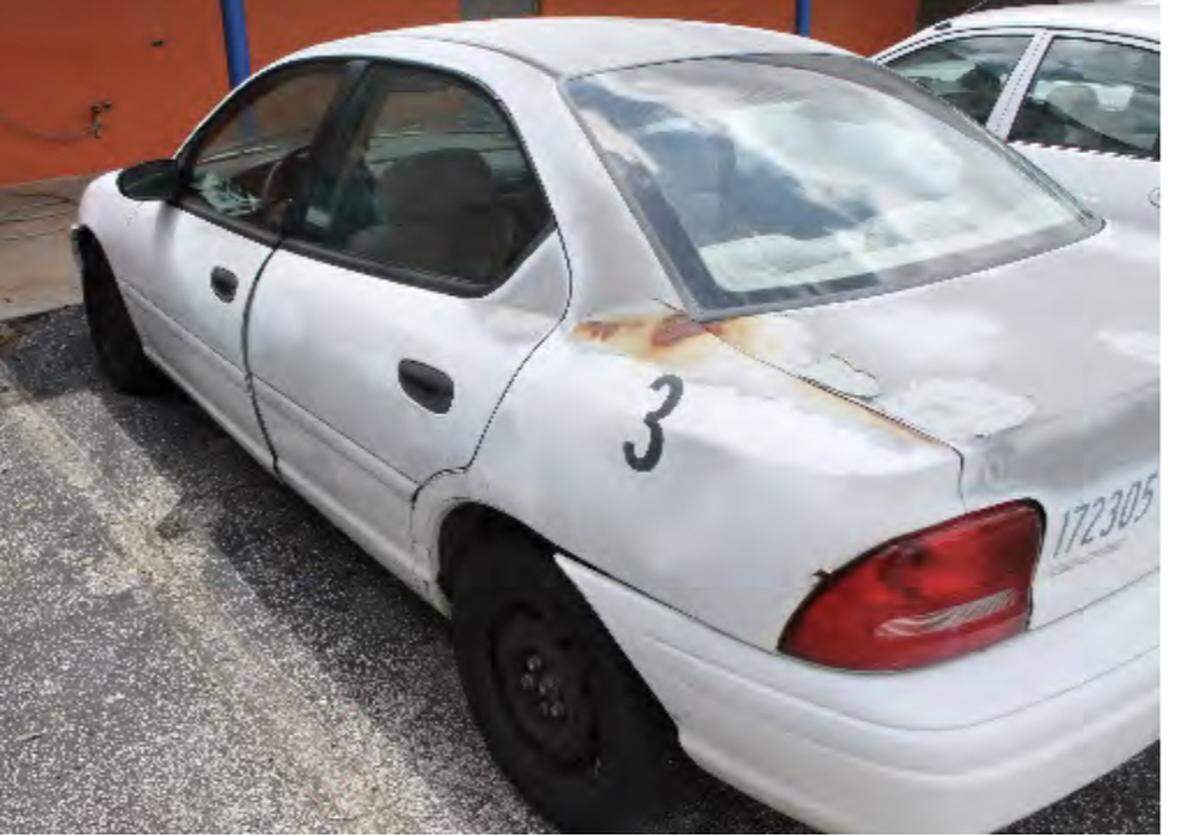 A rusting car is parked in the lot of a Miami-Dade County public school. The vehicle is part of a fleet of cars belonging to the district’s driver education program.