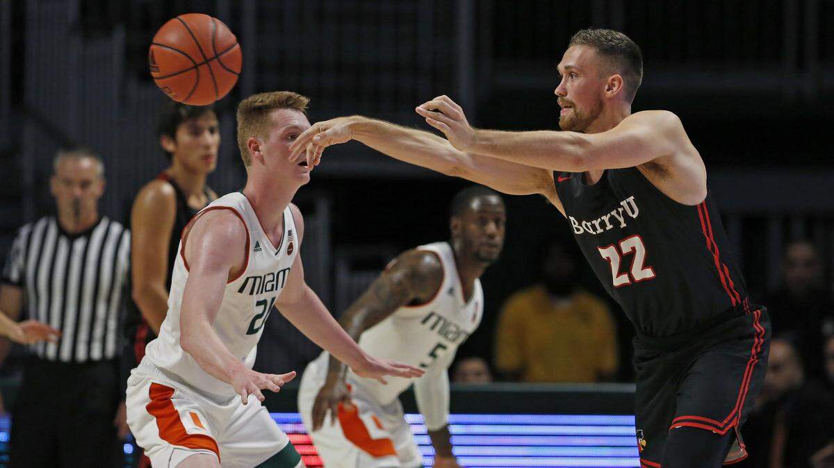 Barry University Buccaneers forward Daniel Mortensen (22) pass the ball against Miami Hurricanes forward Sam Waardenburg during the first half at the Watsco Center in Coral Gables on on Tuesday, Oct. 30, 2018.