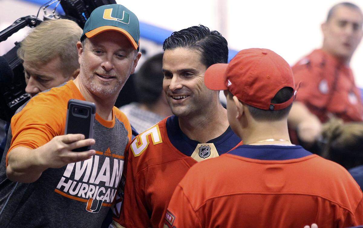 Miami Hurricanes head coach Manny Diaz poses for a picture with fans after the ceremonial puck drop during an NHL hockey game between the Ottawa Senators and Florida Panthers, Sunday, March 3, 2019, in Sunrise, Fla.