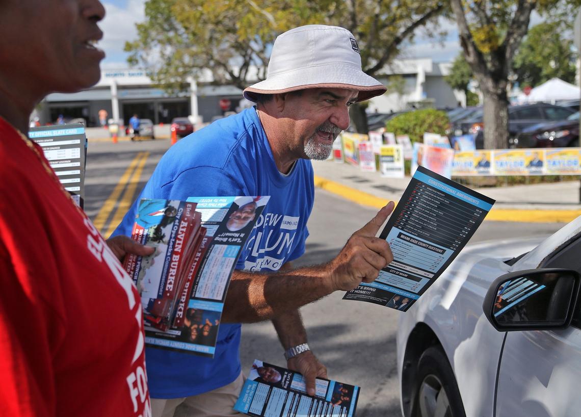 Early voters park at the North Dade Regional Library as Pedro Arjuna, 63, hands out voting materials in hope of swaying votes on Wednesday, Oct. 31, 2018.