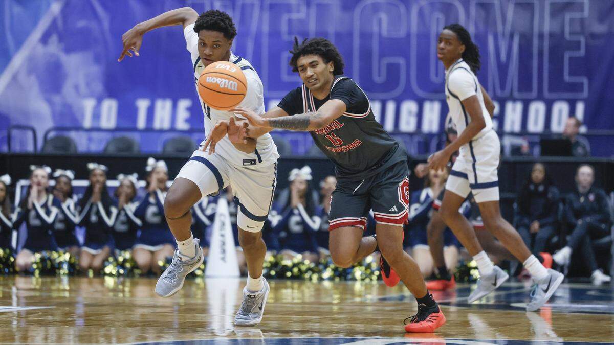 Calvary Christian Academy’s Draydne McDaniel (0) battles Cardinal Gibbons’s Marcus Pierre (15) for a loose ball in the first half during boys 3A basketball semifinal game of the Florida High School State Championships.