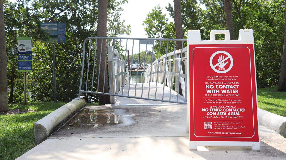A sign in front of the Park View Island Kayak Launch in Miami Beach warns passersby not to touch the water Friday, June 9, 2023.
