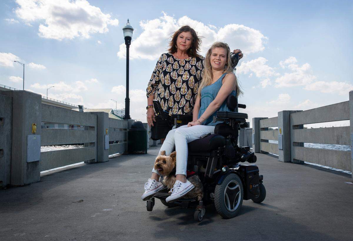 Patricia Parrish with her daughter, Delaina, and her service dog, Kona, at the Titusville pier on Jan. 22, 2021. The year before, Delaina graduated from the University of Florida.