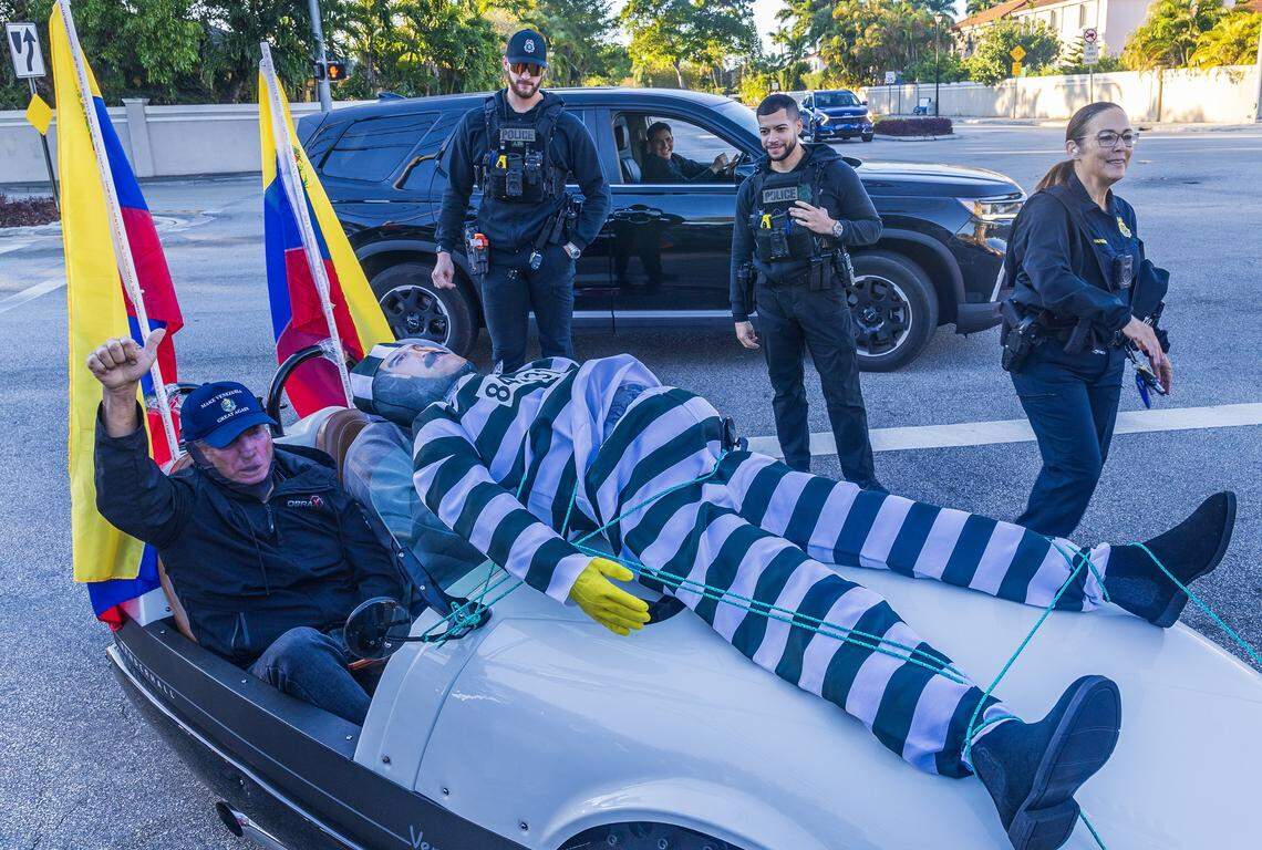 City of Doral Police officers guiding the traffic reacted while two men strapped a mannequin depicting Nicolas Maduro in a prisoner jumpsuit as they arrived to a celebration by Venezuelan exiles living in South Florida outside of El Arepazo in Doral, Florida, after the United States attacked Venezuela and captured Venezuelan leader Nicolás Maduro,  on Jan. 3, 2026.