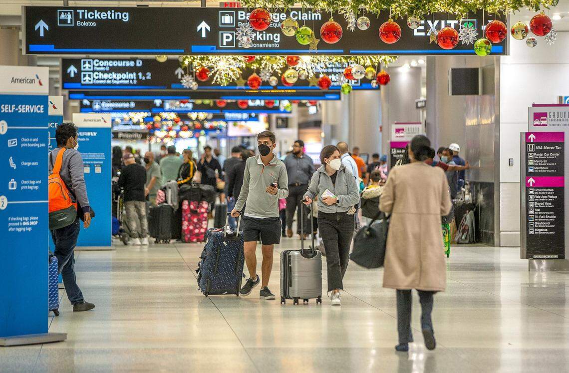 Travelers seen at Miami International Airport where a Covid Testing center is fully busy as COVID-19 infections are surging across the South Florida during the holidays.