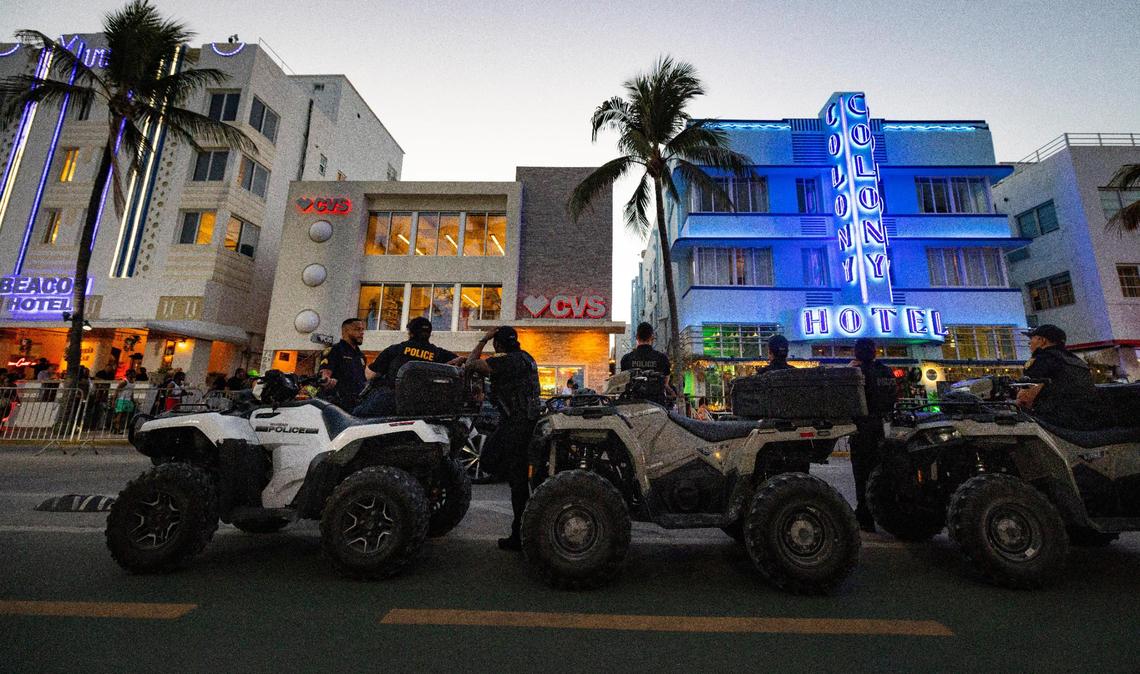 Police stand on Ocean Drive during spring break on Sunday, March 17, 2024.