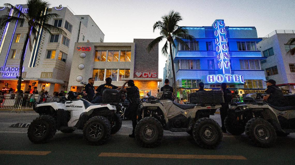 Police stand on Ocean Drive during spring break on Sunday, March 17, 2024.