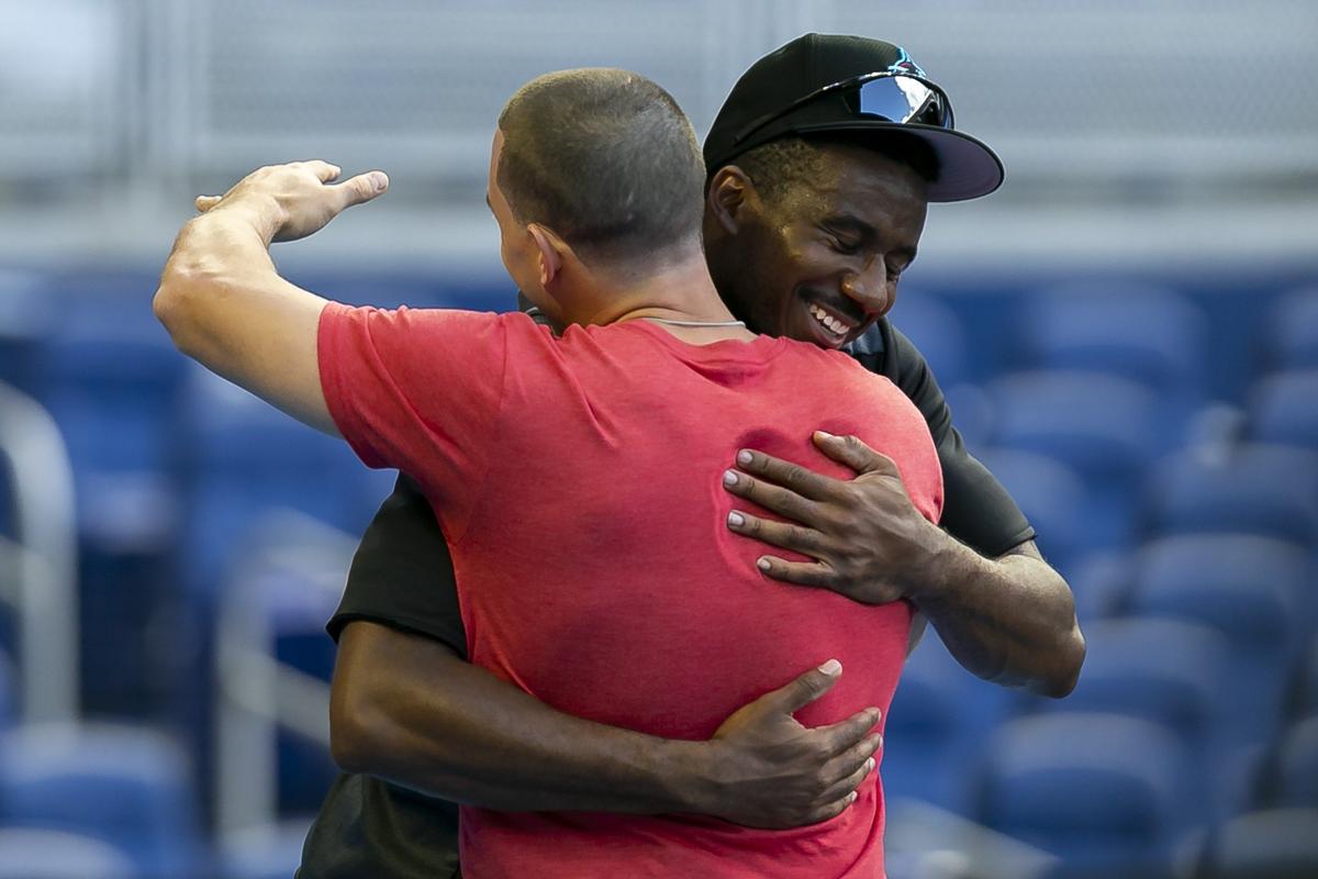 Miami Marlins Lewis Brinson (9) hugs his former teammate Philadelphia Phillies catcher J.T. Realmuto (10) before playing against each other in a regular season baseball game at Marlins Park in Miami on Friday, April 12, 2019.