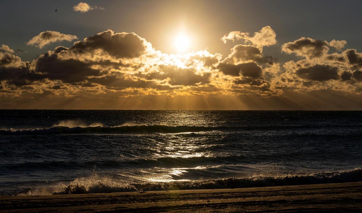 The sun rises near the Hollywood Beach Broadwalk as temperatures dip into the mid 40s on Saturday, Jan. 14, 2023, in Hollywood, Fla.