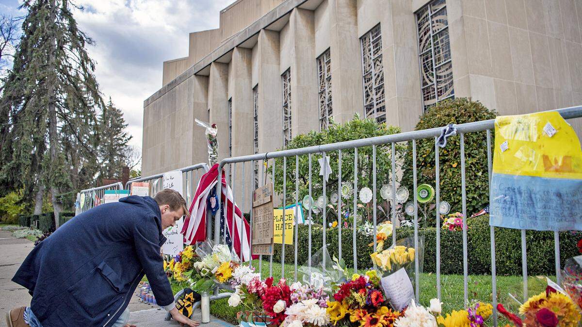 Tyler Brugmann, of Shadyside, places a candle at a memorial outside of the Tree of Life synagogue, which housed the congregations New Light, Dor Hadash and Tree of Life*Or LíSimcha in Pittsburgh on Sunday, Oct. 27, 2019, honoring the lives of the 11 victims killed a year ago in the Tree of Life shooting.