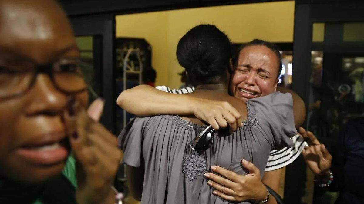 Roshane Eyma, center, cries as she is greeted by members of her church after being rescued and flown to Nassau from devastated Abaco Island.