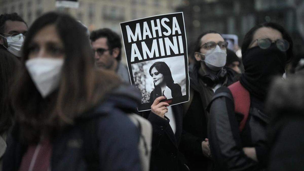 A woman holds a placard with a photo of Iranian Mahsa Amini at a protest in Berlin, Germany, against her death.