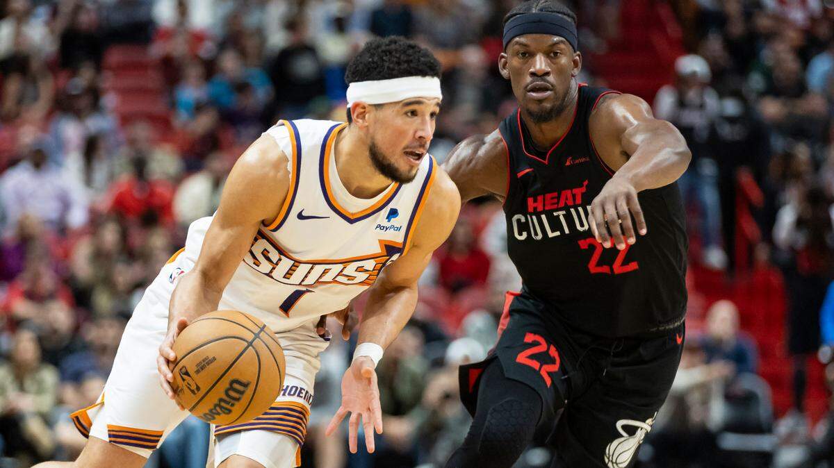 Phoenix Suns guard Devin Booker (1) drives the ball as Miami Heat forward Jimmy Butler (22) defends in the fourth quarter of an NBA game at the Kaseya Center on Monday, Jan. 29, 2024, in downtown Miami, Fla.