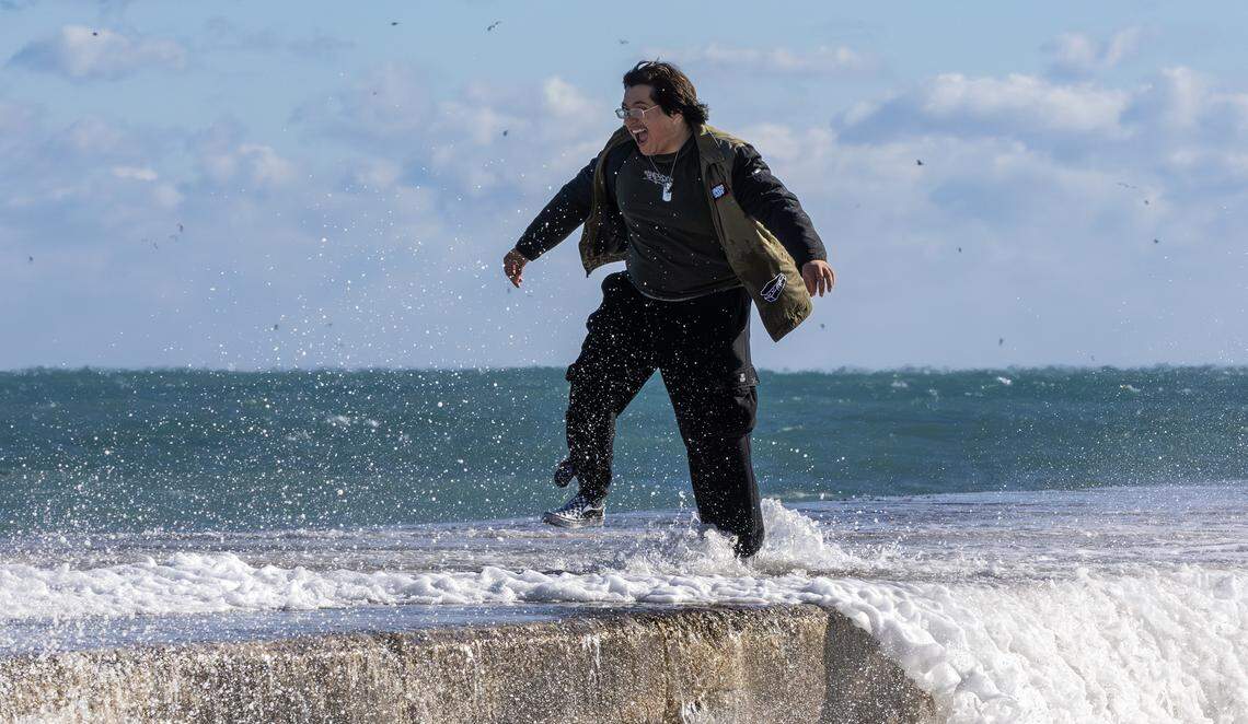 Ryan Romero of Naples, Fla., reacts as waves crash against the jetty near the Bal Harbour Lighthouse on Sunday, Feb. 1, 2026, in Bal Harbour, Fla. Miami saw temperatures drop into the 30s, the coldest in more than 15 years.