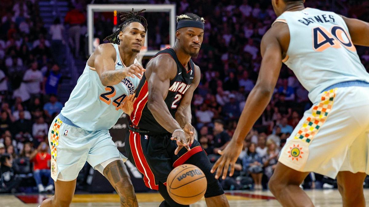 Miami Heat forward Jimmy Butler (22) passes the ball as San Antonio Spurs guard Devin Vassell (24) and forward Harrison Barnes (40) defend in the second half during their NBA basketball game at the Kaseya Center in Miami, Florida on Sunday, January 19, 2025.