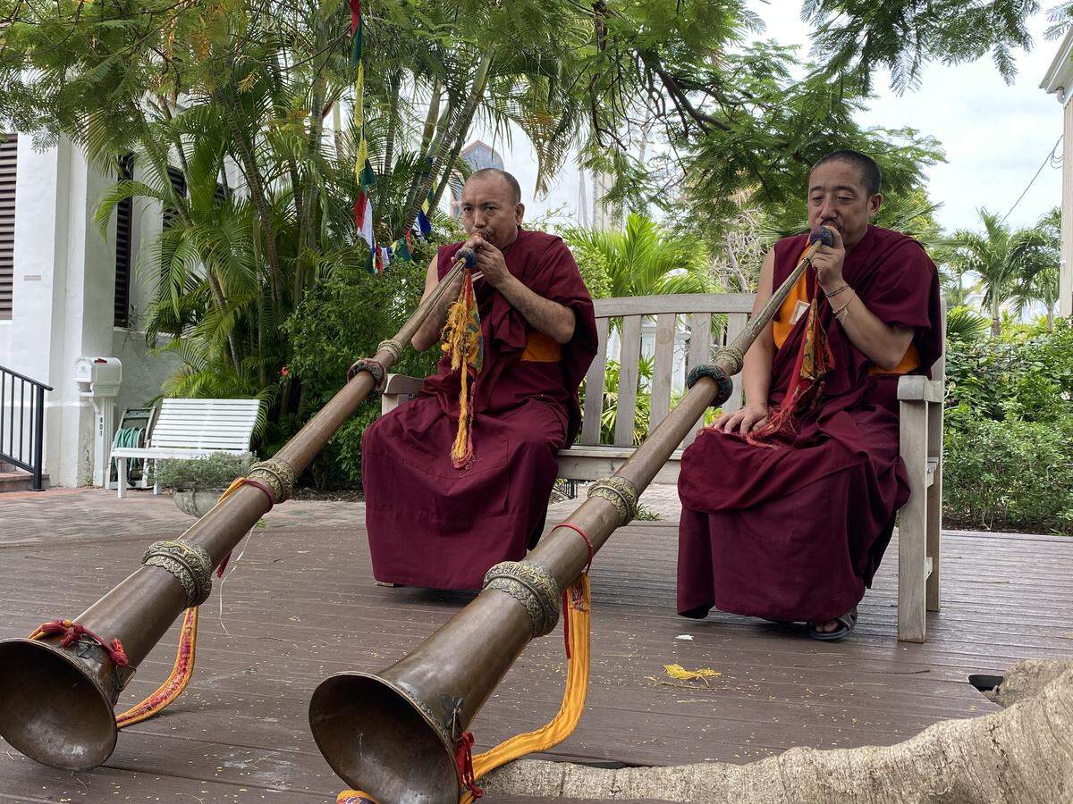 Tibetan monks play the long horn, or dungchen, outside a Key West church on Jan. 19, 2020. The monks are visiting the Keys as part of their 2020 Sacred Arts tour.