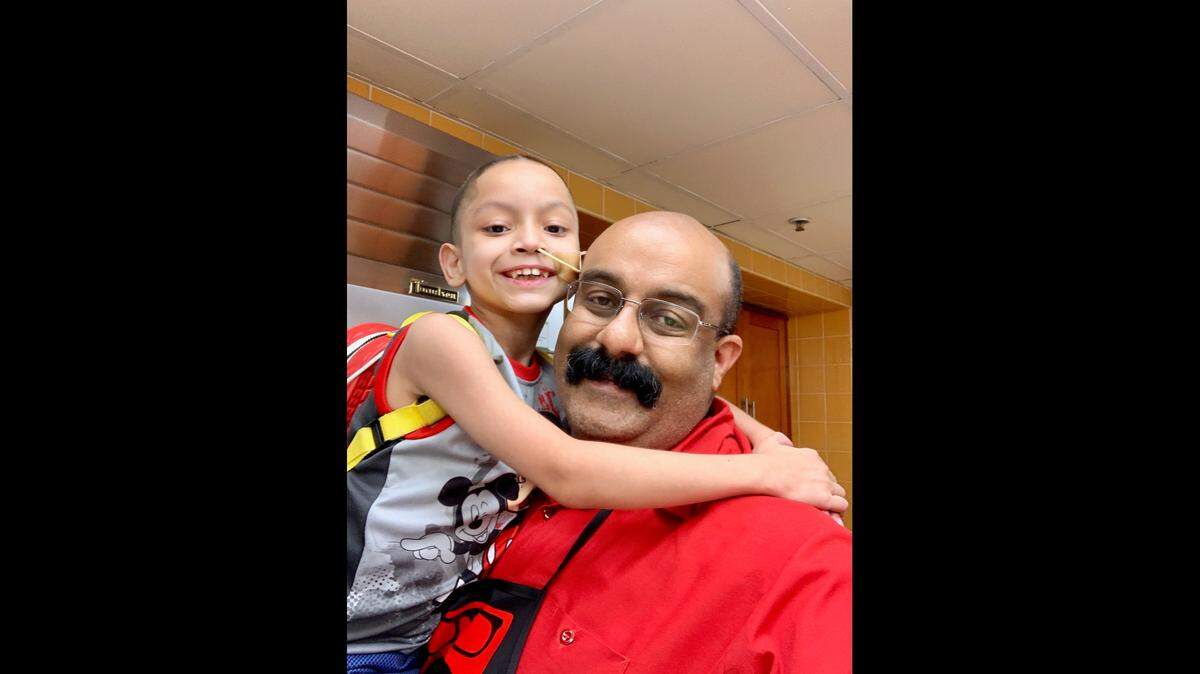 Elliott Scholes, a Miami-Dade police officer, lifts Adonis, a patient at the Ronald McDonald House in Miami. Scholes, his family members, friends, and other police officers in “Elliott & Friends” volunteer to bring comfort and joy to children receiving medical treatment and their families.