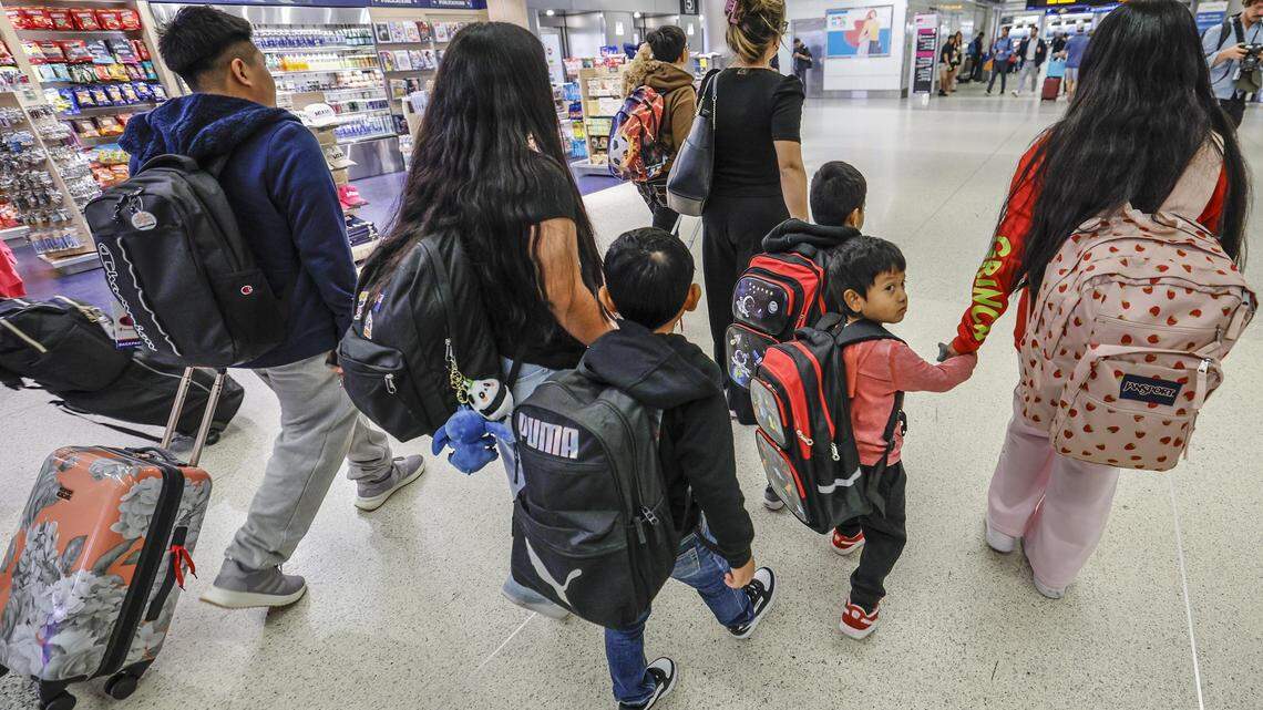Luisa Gutiérrez, in front, escorts seven children from six families who are being flown to Guatemala, departing from Miami International Airport in Miami, Florida, on Thursday, December 4, 2025. The children will reunite with their families in Guatemala after their family members were deported by ICE.