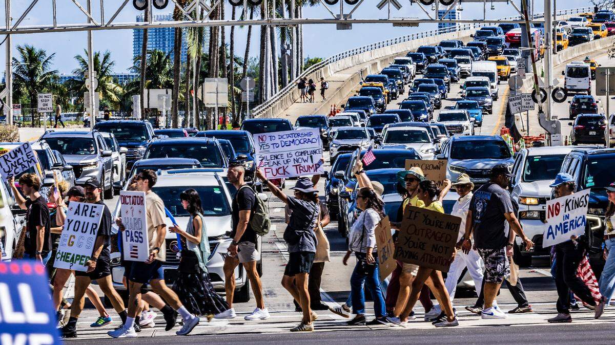 Protesters interrupt the traffic out of PortMiami on Biscayne Boulevard as they march from the Torch of Friendship to the Freedom Tower in downtown Miami. The protests are part of the ‘No Kings’ anti-Trump protests taking place nationwide and  across South Florida on Saturday, Oct. 18, 2025. Thousands of people are expected to take to the streets Saturday, March 28, 2026, for the third nationwide ‘No Kings’ demonstration. 