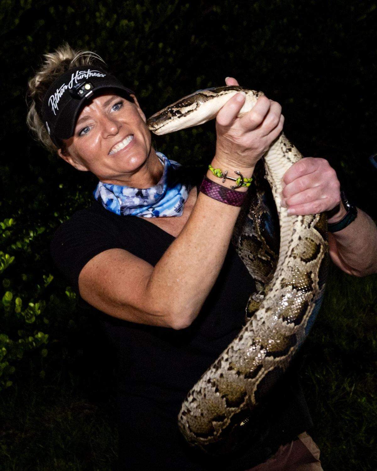Amy Siewe holds an invasive 10-foot Burmese Python.