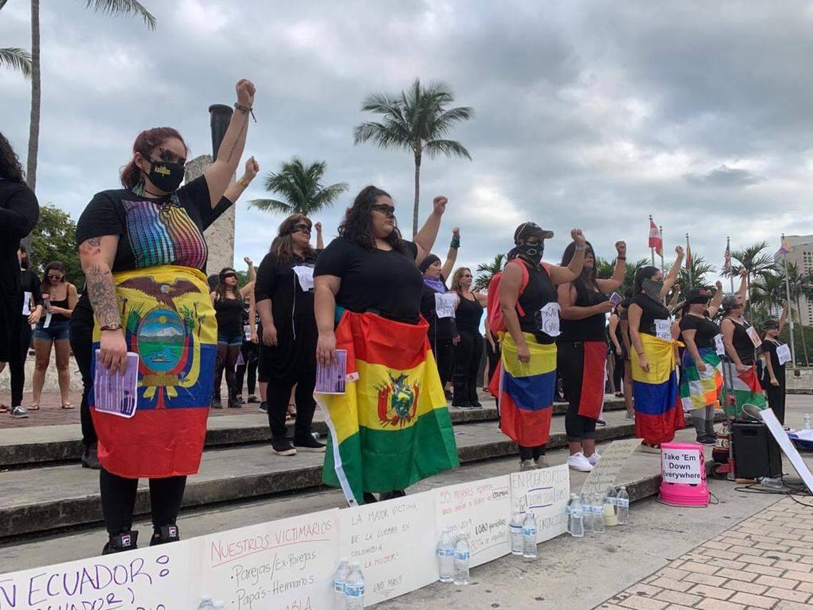 A group of women holding flags from their native Latin American countries raise their left fists in the air to protest violence against women at the “Un violador en tu camino” or “A Rapist In Your Way” demonstration Sunday, December 8, 2019 at the Torch of Friendship in downtown Miami.
