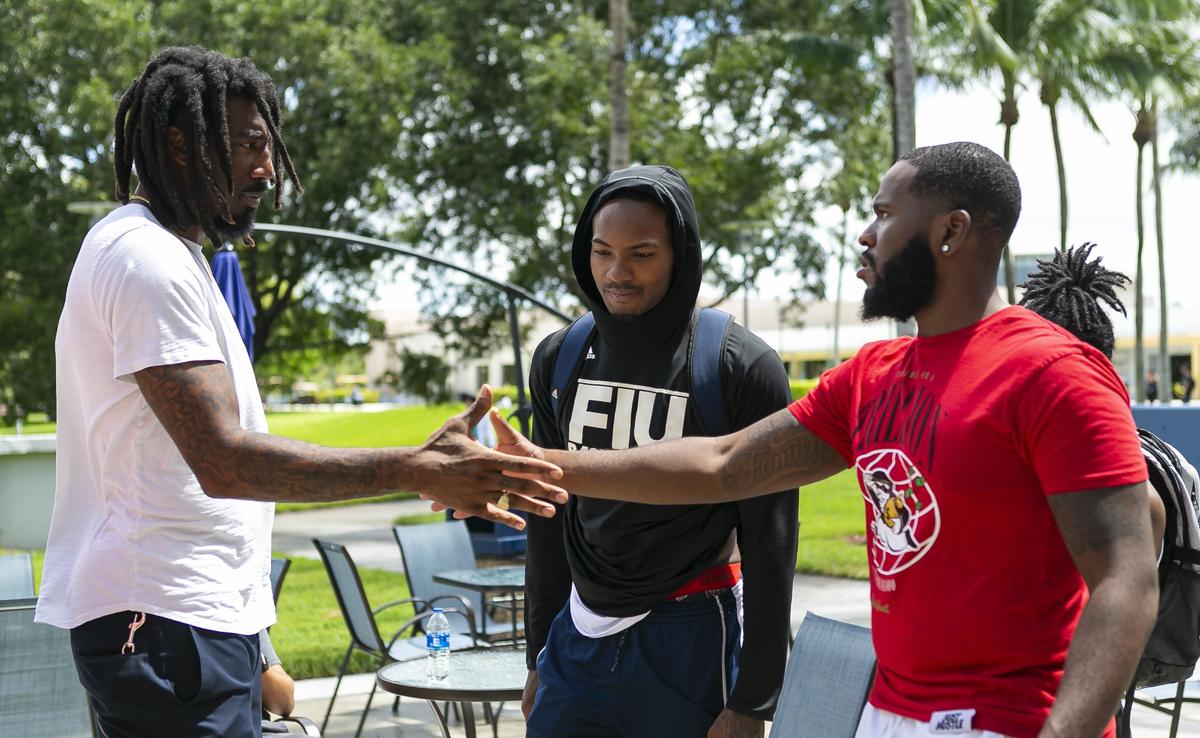 Amar’e Stoudemire, 36, a former NBA player, greets Mark Dixon, 21, far-right, and Devon Andrews, 22, center, while waiting for food at Florida International University on Friday, September 13, 2019. Stoudemire is developing a comprehensive program that seeks to unify the Jewish and African-American students on campus.
