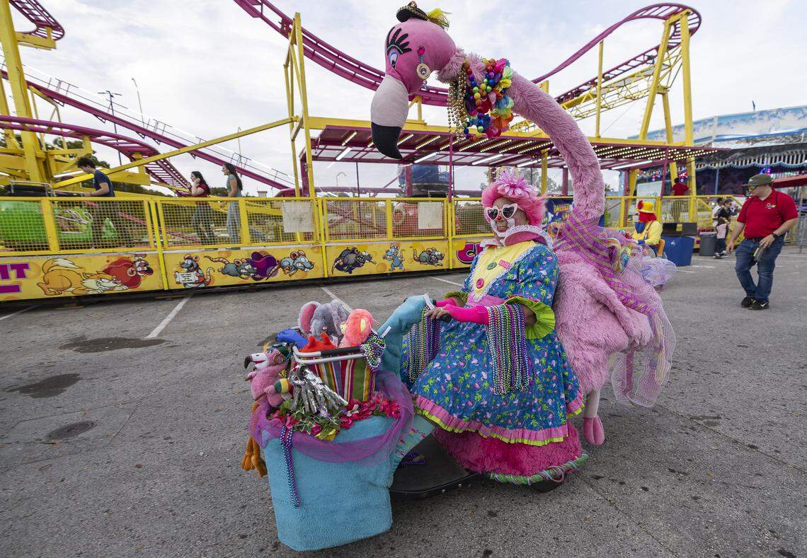 Katie drives a flamingo themed vehicle as she hands festive beads to guests during the opening day of the 74th annual Miami-Dade County Youth Fair on Thursday, March 12, 2026, in Miami, Fla.