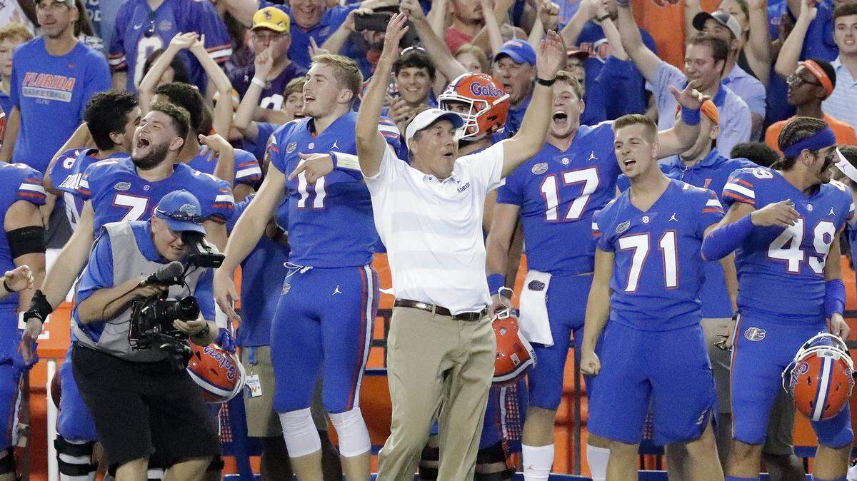 Florida head coach Dan Mullen, center, stands with his players on the sidelines.