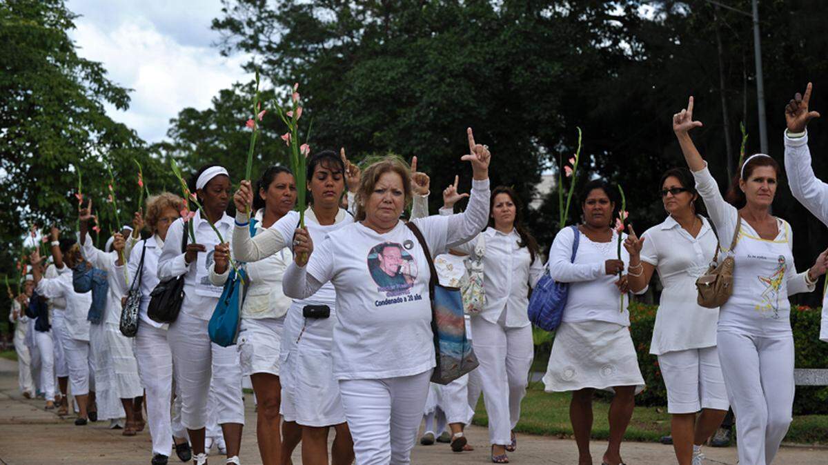 In 2010, members of the Ladies in White make an “L” (for “liberation”) with their fingers as they march in Havana to demand the release of political prisoners.