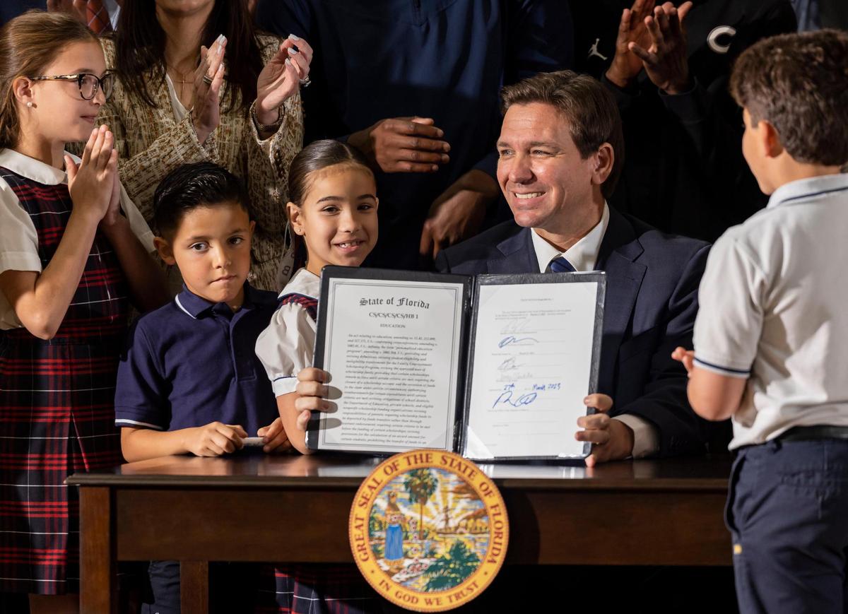 Florida Governor Ron DeSantis signs his expanded school voucher bill into law on March 27, 2023 at Miami’s Christopher Columbus High School. The new law removed income restrictions making vouchers available to everyone.