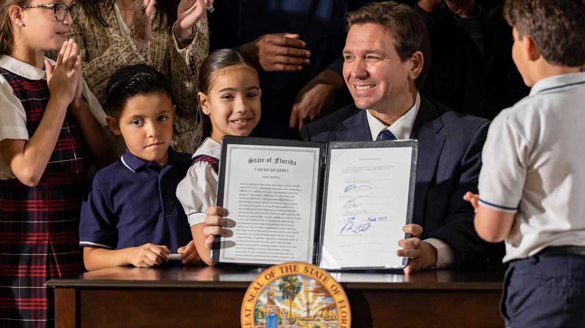Florida Gov. Ron DeSantis reacts after signing a bill to expand school vouchers across Florida during a press conference at Christopher Columbus High School on Monday, March 27, 2023, in Miami, Fla.