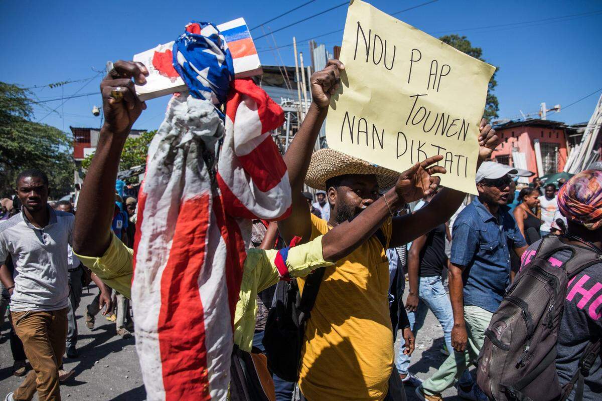 Demonstrators march in Port-au-Prince on February 10, 2021, to protest against the government of President Jovenel Moise. - Haitian police fired tear gas on hundreds of protesters who were marching against President Jovenel Moise and attacked journalists covering the demonstration, in the latest clashes to mark the country’s political crisis. The protesters were accusing Moise of illegally extending his term. He says it lasts until February 2022 -- but the opposition argues it should have ended last weekend, in a standoff over disputed elections. (Photo by Valerie Baeriswyl / AFP) (Photo by VALERIE BAERISWYL/AFP via Getty Images)