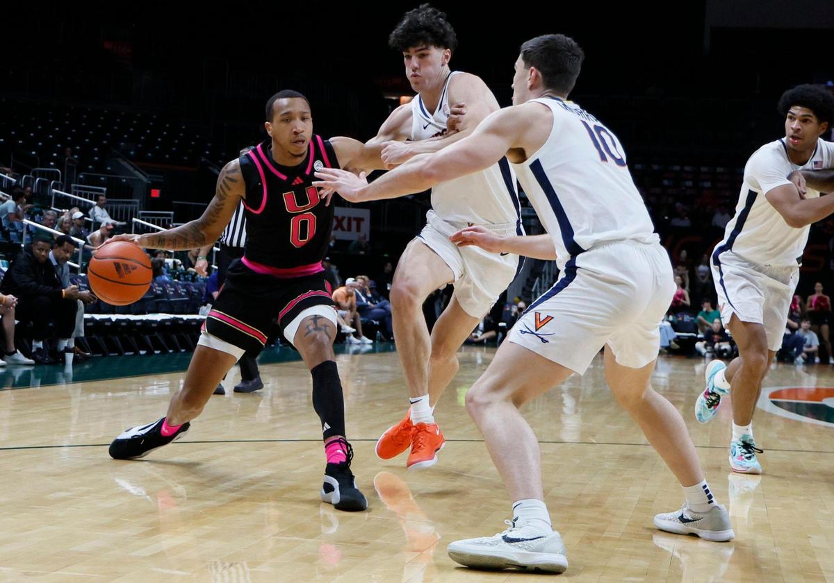 Miami Hurricanes guard Matthew Cleveland (0) drives the ball as Virginia Cavaliers guard Taine Murray (10) and forward Blake Buchanan (0) defend in the first half in their ACC basketball game at the Watsco Center in Coral Gables, Florida on Wednesday, January 29, 2025.