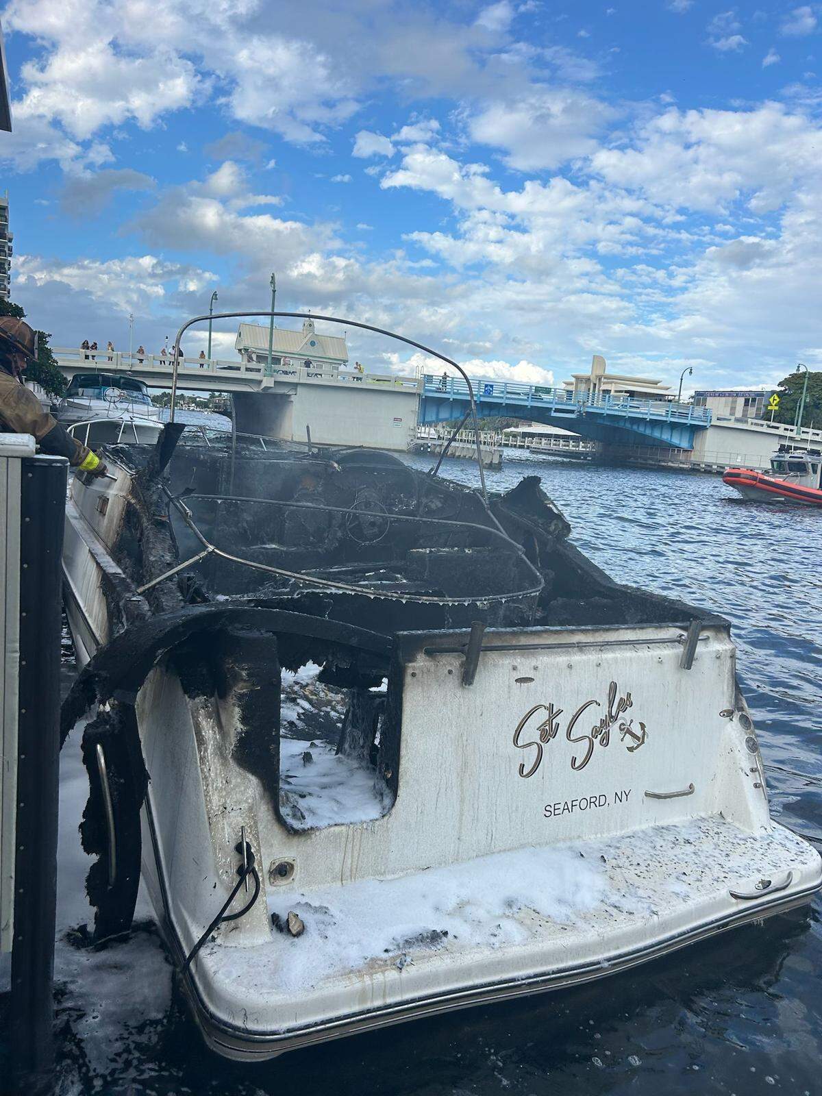Fort Lauderdale firefighters finish extinguishing flames on a boat docked in the Intracoastal Waterway Sunday, Oct. 12, 2025.