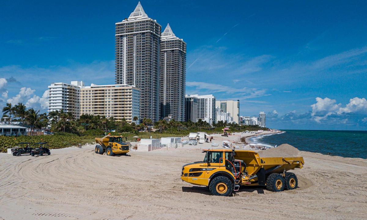 Aerial view shows trucks offloading sand near Indian Beach Park on Wednesday, Oct. 12, 2022, in Miami Beach, Fla.