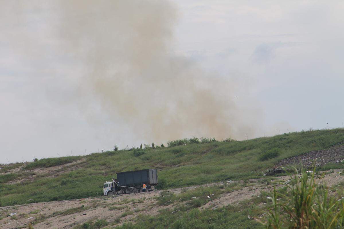 A garbage truck drives past a fire near the top of the south Miami-Dade County landfill Friday, Sept. 25, 2020.