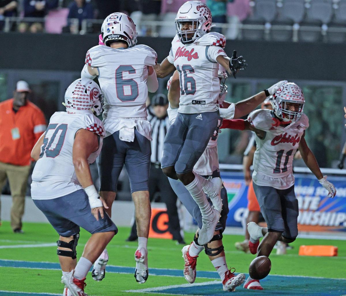 Cardinal Gibbons wide receiver Jesse Anderson (16) celebrates with teammates after scoring in the first quarter against the Cocoa Tigers in the Class 4A title game.