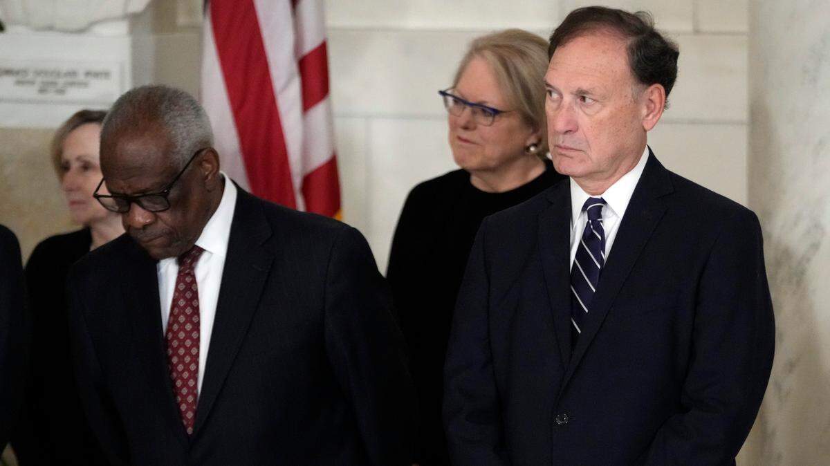 Supreme Court Justice Clarence Thomas, left, and Justice Samuel Alito, right, attend a private memorial ceremony in Washington, D.C. on Dec. 18, 2023 for retired Supreme Court Justice Sandra Day O’Connor following her death. Standing directly behind the justices is Thomas’ wife, Virginia Thomas.