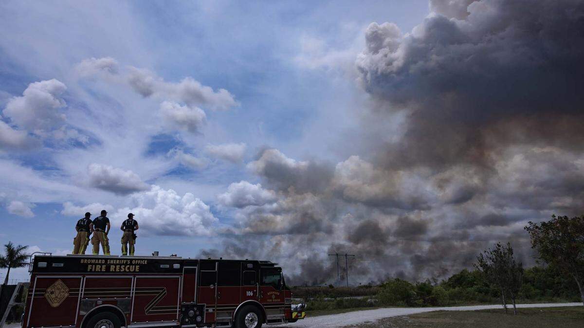 Broward Sheriffs Office Fire Rescue team monitors a wildfire burning west of Weston into the Everglades on Monday, May 11, 2026, seen from Everglades Holiday Park in Fort Lauderdale, Fla.