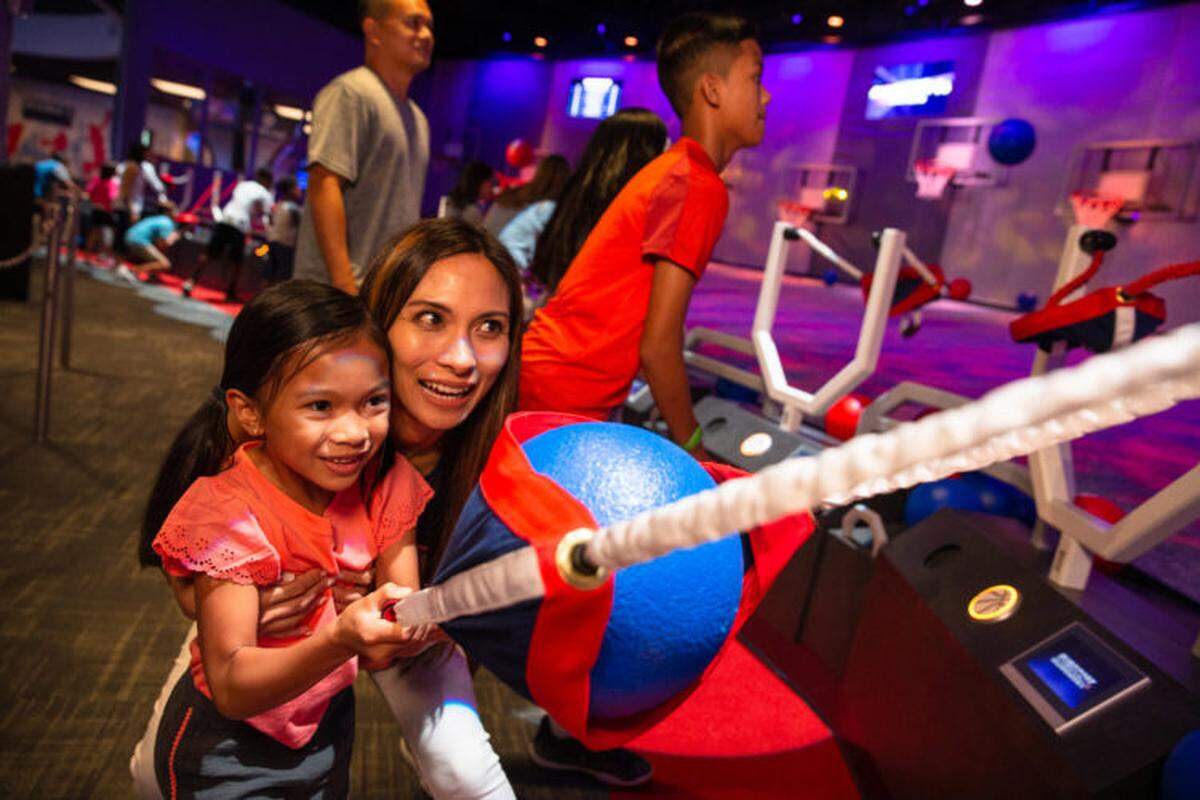 Guests at NBA Experience race against the clock at Slingshot to make as many baskets as possible using an oversized slingshot before time runs out. NBA Experience immerses guests of all ages and skills into the world of professional basketball as both a fan and player at Disney Springs at Walt Disney World Resort in Lake Buena Vista, Fla. (Steven Diaz, photographer)
