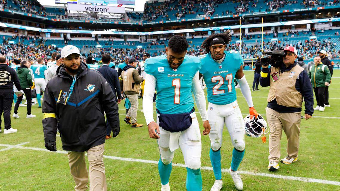 Miami Dolphins quarterback Tua Tagovailoa (1) and Miami Dolphins safety Eric Rowe (21) walk off the field after the Green Bay Packers defeat the Dolphins 26-20 during an NFL football game at Hard Rock Stadium on Sunday, December 25, 2022 in Miami Gardens, Florida.