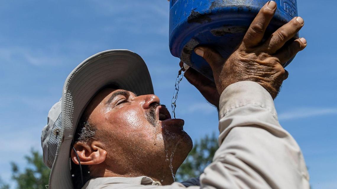 Gilberto Lujano, de 49 años, bebe agua mientras trabaja en un tejado, el martes 2 de mayo de 2023, en Homestead, Florida.