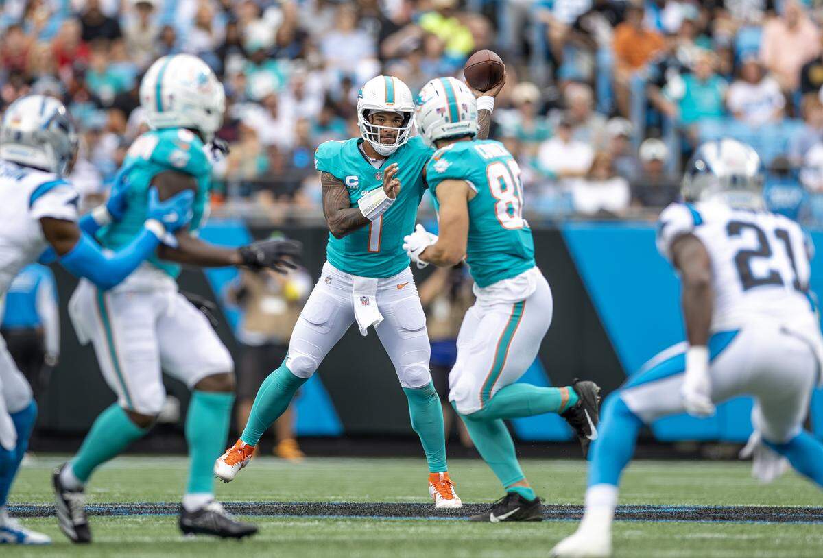 Miami Dolphins quarterback Tua Tagovailoa (1) passes to tight end Tanner Conner (80) during the first half of an NFL game against the Carolina Panthers at Bank of America Stadium, Sunday, Oct. 5, 2025, in Charlotte, N.C.